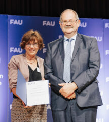 Prof. Jutta Eichler stands next to the Dean of the Faculty of Natural Sciences, Prof. Jürgen Schatz and present the award certificate